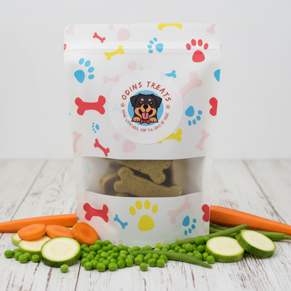 Veggie Dog Treat Cookies with fresh carrots, peas, zucchini and green beans on rustic wooden surface